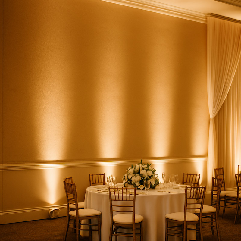 Warm white uplights washing a reception wall